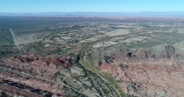 Escena aérea de drones del verde valle del río Huaco entre coloridas montañas plegadas. Antecedentes de ciudad rural y tierras productivas. Huaco, provincia de San Juan, Argentina — Vídeo de stock