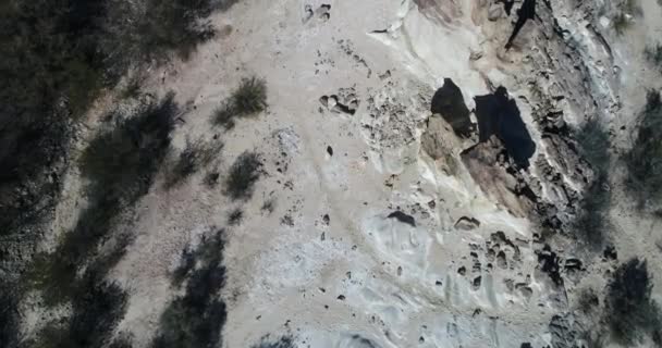 Εναέρια senital σκηνή drone πετώντας πάνω από βραχώδεις σχηματισμοί που αναδύονται από τη γη με γωνία. Το Top view βράχους των βουνών διπλωμένο. Επαρχία Σαν Χουάν εγγενή βλάστηση, Huaco, Αργεντινή — Αρχείο Βίντεο