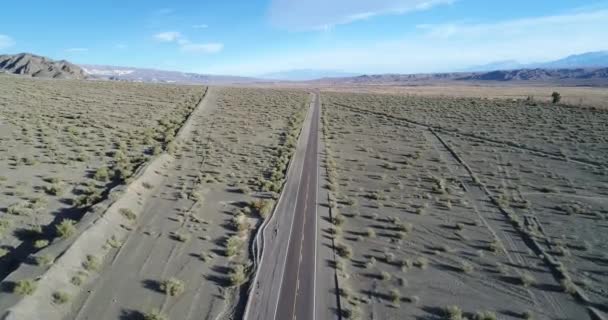 Letecká drone scéně auto cestování přes silnici v údolí řeky mezi erodované písečných dunách. Čas západu slunce. Calingasta, San Juan, Argentina. — Stock video