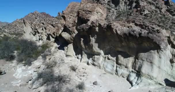 Escena aérea de drones de valle seco y montañas plegadas. La cámara muestra detalles de formaciones rocosas que emergen de la tierra con ángulo, moviéndose de la vista frontal a la senital. Provincia de San Juan, Huaco, Argentina — Vídeo de stock