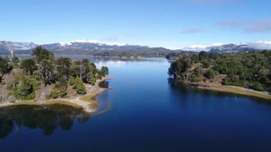 Alumine Gölü, Villa Pehuenia, Moquehue, Neuquen, Patagonya Arjantin hava dron sahne. Kamera Adaları arasında ileriye doğru hareket. Kar ve arka planda evleri ile Dağları.