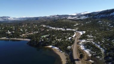 Alumine Gölü, Villa Pehuenia, Moquehue, Neuquen, Patagonya Arjantin hava dron sahne. Kamera aşağı doğru hareket. Dağ aracaria araucana ağaçlar, kar ve evler. Araba ile yönlendirmek.