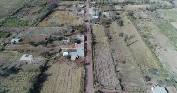 Cena de drones aéreos de paisagem rural com pequenas plantações. Câmera movendo-se para a frente em alta altitude, seguindo a estrada de cascalho, vista superior. Villa Union, província de Rioja, Argentina — Vídeo de Stock