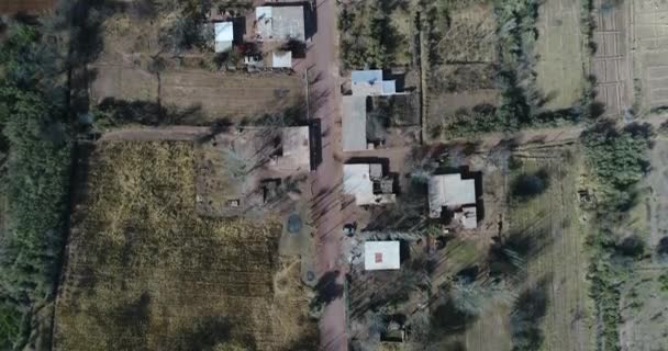 Légi senital drone jelenet a kis mezőgazdasági termelők vidéken. Murvás úton mozog. Családi házak, a fák és a növények a külvárosokban a Villa Unió, Rioja tartomány Argentínában. Cuyo — Stock videók