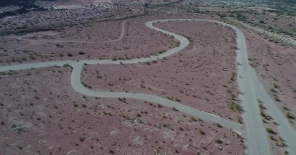 Vue senitale de la piste de course automobile sur un paysage désertique rouge sec. Deux motos s'entraînent sur la piste. Villa Union infrastructure sportive. Rioja province, Argentine — Video