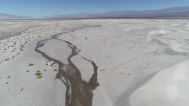 Hava dron sahne tepeleri ve bitkiler ile Kum Çölü ve arka plan üzerinde belgili tanımlık andes dağ. Meandrean nehire yakın manzara keşfetmek zemin üzerinde ilerlemeye. Taton, Catamarca, Argentina
