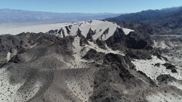 Antenn drönare scen över bergen med sanddyner och sandöknen med några gröna växter. Kameran rör sig framåt upptäcka landskapet. Taton, provinsen Catamarca, Argentina. — Stockvideo