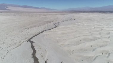 Hava dron sahne tepeleri ve bitkiler ile Kum Çölü ve arka plan üzerinde belgili tanımlık andes dağ. Meandrean nehire yakın manzara keşfetmek zemin üzerinde ilerlemeye. Taton, Catamarca, Argentina