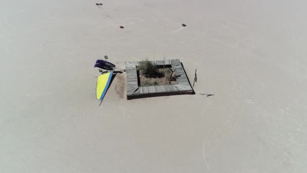 Aerial drone scene top view, senital, of detail of tipped over wind cart for races at barreal desert in aimogasta, la rioja, Argentina. Camera moving around car and wooden abandoned seats . — Stock Video