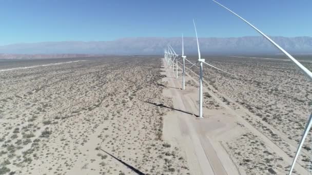 Légi drone jelenet a szél területen teljes igazított szélturbinák Aimogasta, la rioja, Argentína. Generációs fenntartható zöld tiszta energia. A kamera megy előre. Az Andok-hegységre a háttérben. — Stock videók