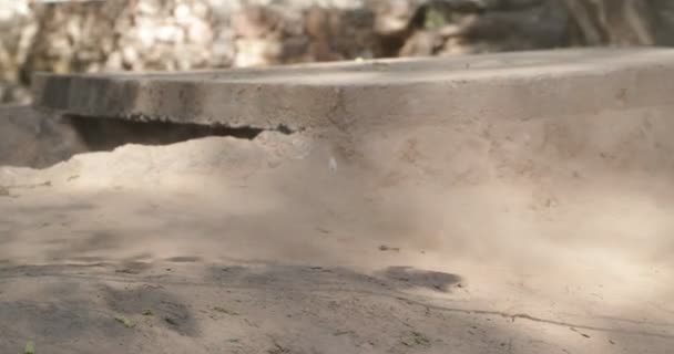 Détail de route de gravier et roue de vélo passant très vite. De la poussière dans l'air. Course cycliste à Londres, Province de Catamarca, Argentine . — Video