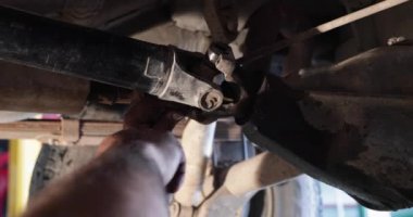 Mekanik tamir, kardan conection yaşlı arabada fark için temizlik. Eller bir adam olay yerinde görünür