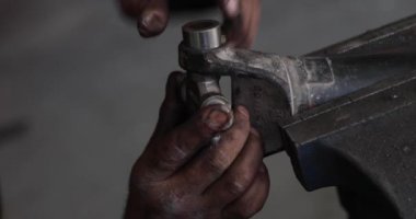 Mekanik bir kardan evrensel çapraz eklem yerine çekiç kullanarak. Eller diry creace ile olay yerinde görünür.