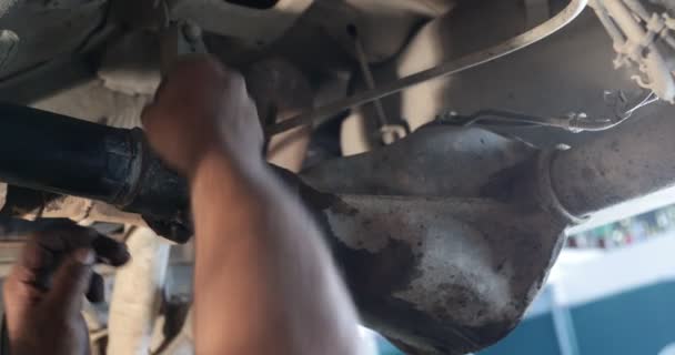 Monteur reparatie van cardan. Man plaatsen module ring met behulp van bout en moer in universele cross gezamenlijke cardan gezamenlijk vast te stellen. Man vuile vertolkt handen verschijnen op het toneel — Stockvideo