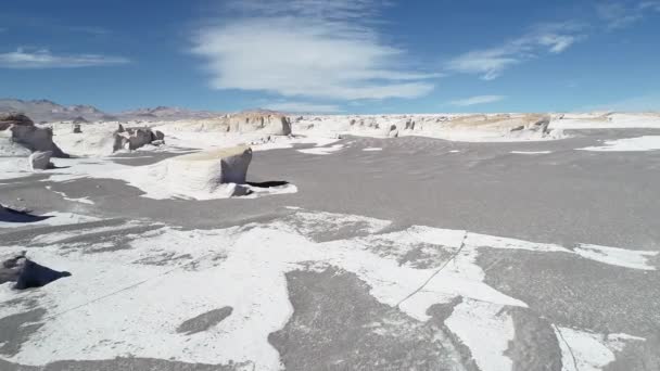 Légi drone jelenet, a mező fehér és narancssárga az horzsakő. Repülő sziklák és a szürke homokos talaj felett. Furcsa földtani desertic régió: catamarca, Argentína — Stock videók
