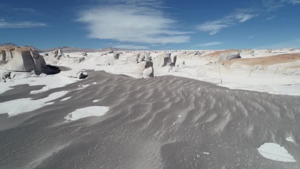 Drohnen-Szene aus der Luft, die aus sandigem, grauen Boden aufsteigt und endloses weißes Bimssteinfeld entdeckt. graue sandige Berge im Hintergrund. — Stockvideo