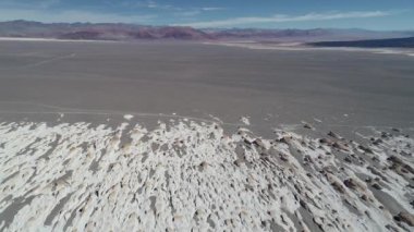 Volkanik manzara, hava uçak sahne beyaz kayalık yapılar üzerinde uçan, ponza eğe. Renkli dağlar ve lav arka plan, siyah yatak. Antofagasta de la Sierra, Catamarca, Argentina