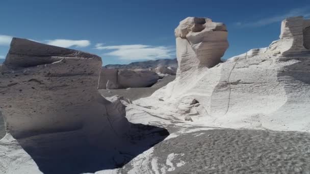 Légi drone jelenet fehér természetes sziklás a struktúrák, az horzsakő mező. Visszafelé repülő ember nézi a táj felett. Antofagasta de la Sierra, Catamarca, Argentína — Stock videók