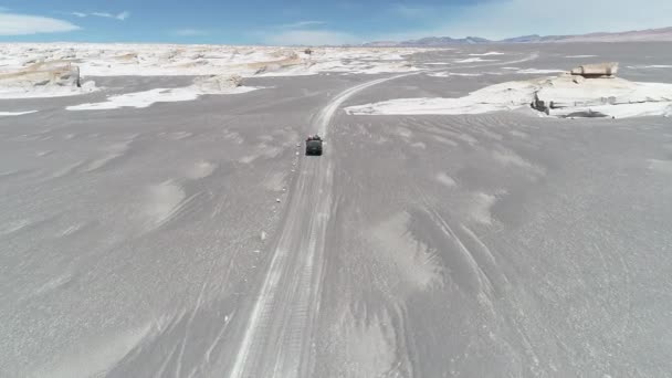 Antenn drönare scen av van kör off road på grå desert omgivet av vita naturliga stenig sturctures av pimpsten fält. Antofagasta de la Sierra, Catamarca, Argentina — Stockvideo