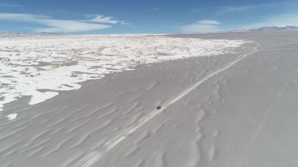 Antenn drönare scen av 4 x 4 van kör off road i bred Miga landskap, vit pimpsten fältet och grå sandig öken, allmänna syn på bred vulkaniska dalen. Catamarca, Argentina — Stockvideo