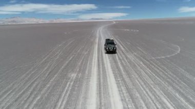 Üzerinde gri çöl off road sürüş açık bir sefer van yükseltmesinin hava dron sahne. Arka plan aşınmış Derma Dağları. Antofagasta de la Sierra, Catamarca, Argentina