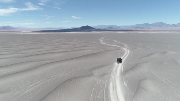 Antenowe scena van jazdy off road w wulkanicznym regionie pustyni. Spektakularne czarny wulkan Carachi Pampa w tle. Wyprawa w krajobraz. Antofagasta de la Sierra, Catamarca, Argentyna — Wideo stockowe