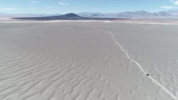 バン砂漠の火山地域でのオフロード走行の空中シーンは。背景に壮大な黒 Carachi パンパにある火山。不毛の風景に遠征。アントファガスタ ・ デ ・ ラ ・ シエラ、アルゼンチンのカタマルカ — ストック動画