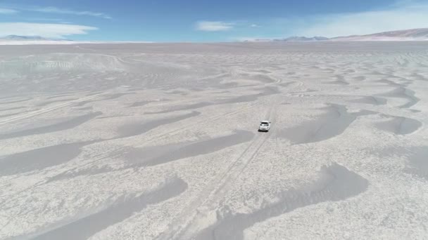 Antenn drönare scen efter en expedition van kör off road på grå öknen. Eroderad colorfull berg i bakgrunden. Antofagasta de la Sierra, Catamarca, Argentina — Stockvideo