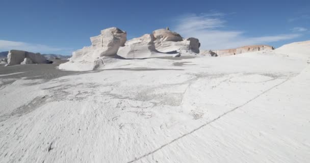 Gimbal stabilized camera movement in Campo de Piedra Pomez, Antofagasta de la Sierra, Catamarca Province, Argentina. Walking over gray sand and white cracked pumice rocks between natural scultures. — Stock Video
