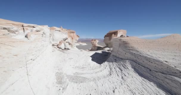 Κύμβαλο σταθεροποιημένο κάμερα κυκλοφορίας ταξιδεύουν μεταξύ βράχια άσπρη ελαφρόπετρα ραγισμένα. Φόντο από λευκό φυσικό ηφαιστειακό γλυπτά. Campo de Piedra Pomez, Antofagasta de la Sierra, Catamarca, Αργεντινή. — Αρχείο Βίντεο