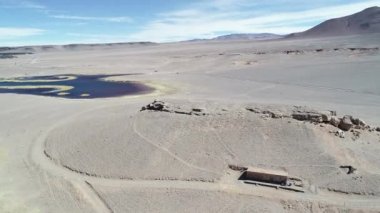 Mavi ve sarı lagün ile beyaz çöl hava dron sahne. Araba römork ile doğru uçan, karavan, omuz durdu. Antofagasta de la Sierra, Catamarca, Argentina