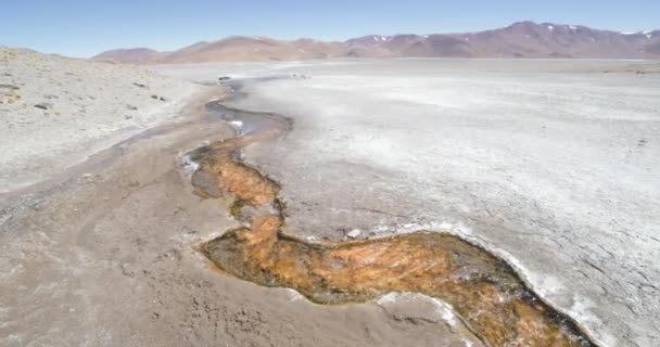 Rivière méandrique orange chaude avec vapeur d'eau montant dans un paysage montagneux désertique blanc. Expédition Volcan Galan, Antofagasta de la Sierra, Catamarca, Argentine — Video