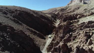4 x 4 van Caddesi üzerinde kırmızı dar bir kanyonda sürüş hava dron sahne. Galan volkan gezi, Antofagasta de la sierra, catamarca, Arjantin