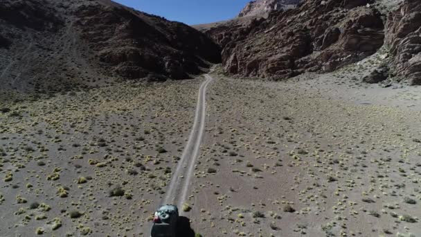 Antenn drönare scen av 4 x 4 van köra av vägen mot en smal röd kanjon. Galan vulkan utflykt, Antofagasta de la sierra, catamarca, argentina — Stockvideo