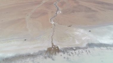 Hava dron sahne detay küçük Nehri'nin ağız, Antofagasta de la Sierra, platolarının Atacama, Catamarca Eyaleti, Arjantin. Diamante lagün, Galan volkan. Kamera hareketli ileri Nehri üzerinde. Hiçbir bitki örtüsü.