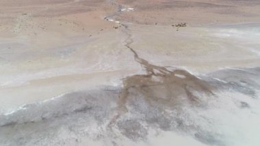 Hava dron sahne detay küçük Nehri'nin ağız, Antofagasta de la Sierra, platolarının Atacama, Catamarca Eyaleti, Arjantin. Diamante lagün, Galan volkan. Kamera hareketli ileri Nehri üzerinde. Hiçbir bitki örtüsü.
