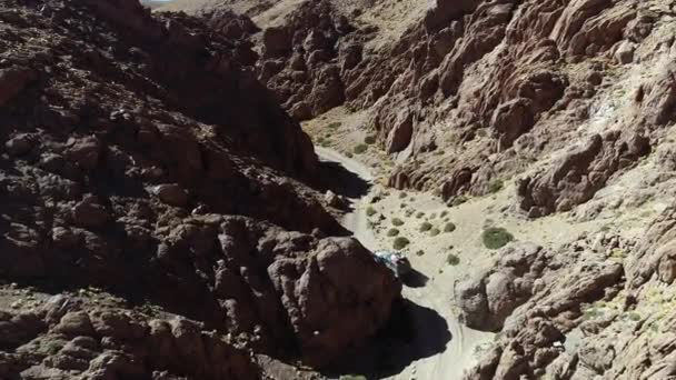 Escena aérea de drones de camioneta 4x4 conduciendo lentamente fuera de la carretera en un estrecho cañón rojo. Excursión al volcán Galán, Antofagasta de la sierra, catamarca, Argentina — Vídeo de stock