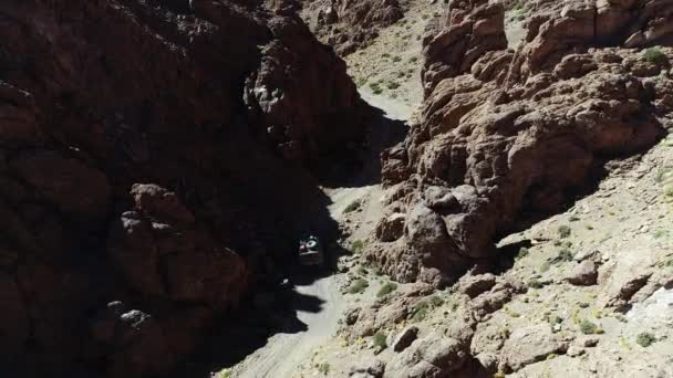 Drone aereo scena di primo piano 4x4 van guida lentamente fuori strada in uno stretto canyon rosso. Escursione vulcano Galan, Antofagasta de la sierra, catamarca, argentina — Video Stock