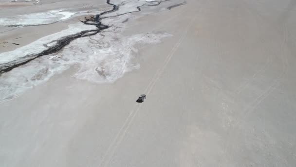 Senital scena drone aerea di 4x4 van guida fuori strada lungo il fiume salato nel paesaggio desertico al cratere vulcano Galan. Escursione ad Antofagasta de la Sierra, Catamarca Argentina — Video Stock