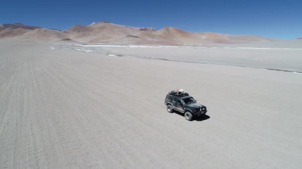 在加兰火山火山口的沙漠景观中, 从前面驾驶的四轮驱动面包车驶出咸河旁的道路后, 空中无人机场景。阿根廷卡塔马卡安托法加斯塔·德拉谢拉之旅 — 图库视频影像