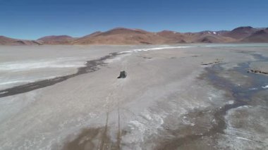 4 x 4 van desertic peyzaj Galan yanardağ krater, tuzlu nehir yanında off road sürüş tarafı aşağıdaki hava dron sahne. Antofagasta de la Sierra, Catamarca Arjantin gezi
