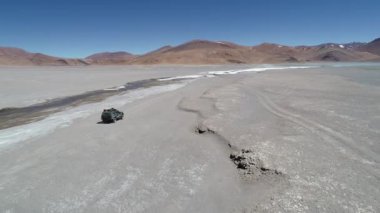 4 x 4 van Galan yanardağ krater desertic manzaraya karlı nehirde yanında off road sürüş tarafı aşağıdaki hava dron sahne. Antofagasta de la Sierra, Catamarca Arjantin gezi