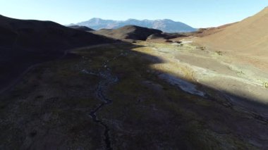 Çöle aşınmış dağların etrafındaki nemli vadinin havadan genel görünümü. Meandric, nehir çizimleri ve bitki örtüsü. Antofalla, Catamarca, Arjantin