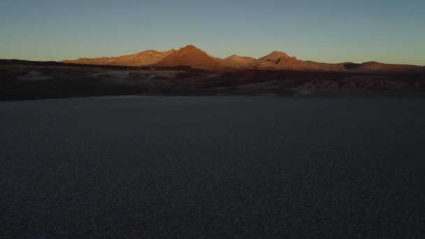 Cena de drone aéreo de salar branco ao pôr-do-sol. Antecedentes de colinas castanhas desertas erodidas. Voando em direção a montanhas perto do piso salar. Salar de Arizaro, Salta, Argentina — Vídeo de Stock