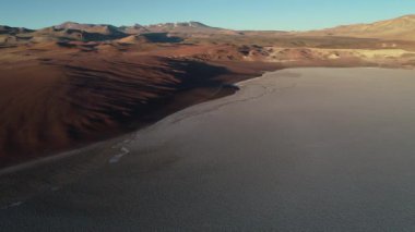 Kahverengi çöl dağları ile beyaz salar sınırı hava drone sahne. Aşınmış manzaranın genel görünümü. Salar de Arizaro, Salta, Arjantin