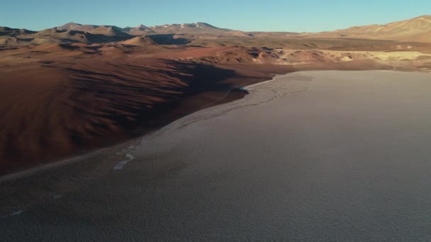 Escena aérea de dron de límite de salar blanco con montañas desérticas marrones. Vista general del paisaje erosionado. Salar de Arizaro, Salta, Argentina — Vídeo de stock