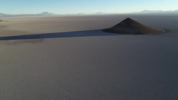 Cena aérea voando em direção à pirâmide natural em branco e salar, visão geral do cone impressionante. Hora do nascer do sol. Longa sombra e contraste. Cono de Arita, Salta, Argentina — Vídeo de Stock