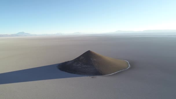 Lucht scène vliegen weg afdalen van natuurlijke piramide bij wit en Salar, algemeen zicht op indrukwekkende kegel. Zonsopgang tijd. Lange schaduw en contrast. Cono de Arita, Salta, Argentinië — Stockvideo