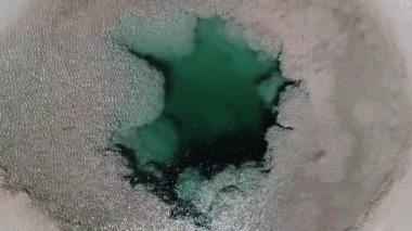 Senital havadan insansız hava aracı, mavi deniz kıyısının stromatolit denilen yapıları, deniz gözleri, Arizaro salar'daki ojos de mar gibi kayalarla detayı. Rüzgar su yüzeyinde dalgalanmalar yapıyor. Tolar grande