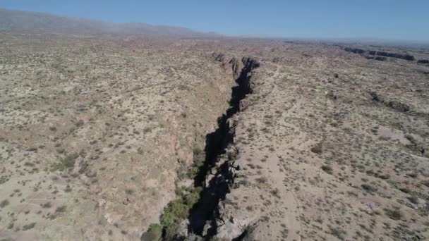 Kanyon boyunca kuru, çölkırmızısı, manzarada uçan hava drone sahnesi. Dağlar ve arka planda daha fazla kanyon. Rioja Eyaleti Arjantin Hualco kanyon. Yerli monte bitki örtüsü — Stok video